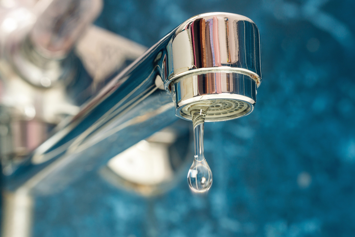 a-drop-of-water-drips-from-a-leaky-faucet