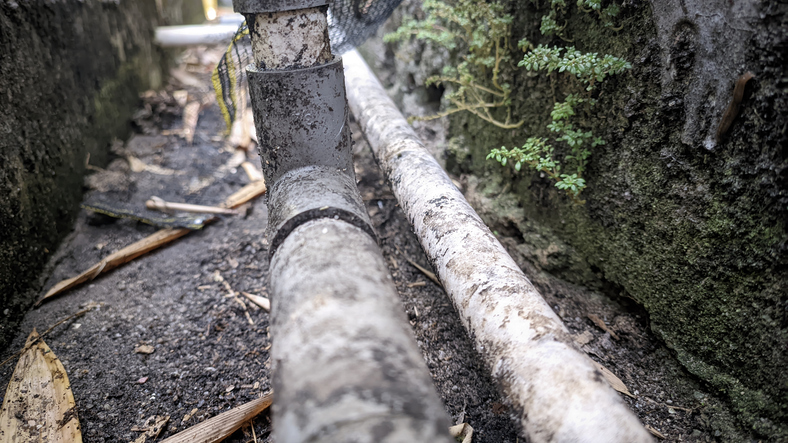 a-collection-of-old-water-pipes-that-are-dirty-and-mossy