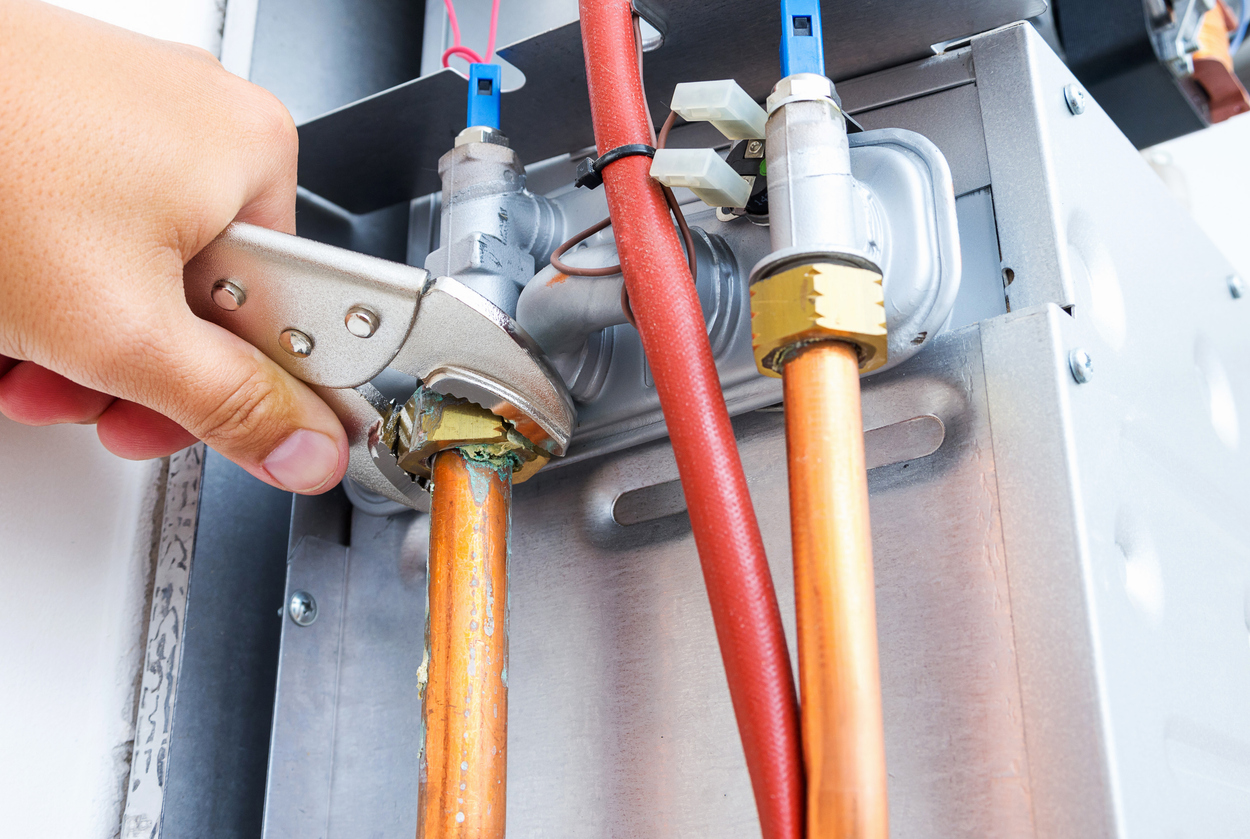 plumber-repairing-a-gas-boiler-of-a-heating-home-system-in-the-boiler-room-close-up-selective-focus